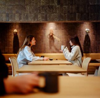 中洲博多座周辺の穴場カフェバーSKIFFでコーヒーとカフェラテを飲みながら女子会をするプライベートサウナ後の女性二人