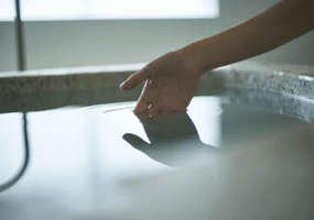 掛け流し上質なプライベートサウナ超軟水の水風呂をたしかめている女性の手