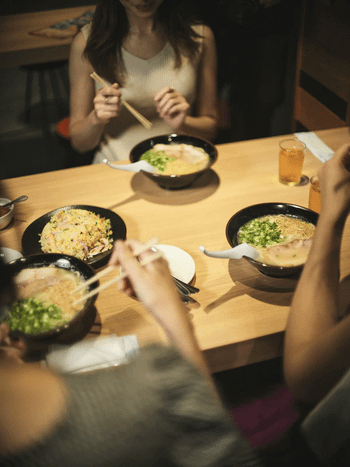 福岡博多のサ飯で、とんこつラーメンとチャーハンを楽しむ女性