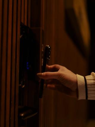 ルームドアのQRコードリーダーにかざすスマホ