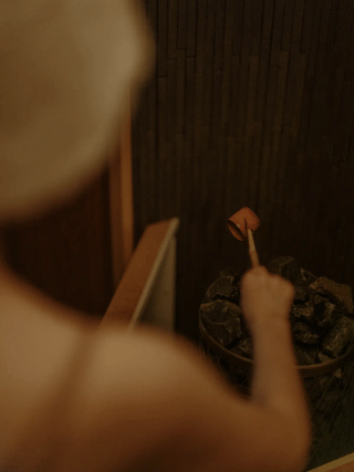 ロウリュをそそぐ女性