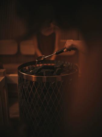 サウナストーンにロウリュ水をかける