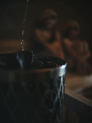 サウナストーンにロウリュ水をかける