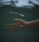 とろけて浸透する超軟水の水風呂を楽しむ女性の手
