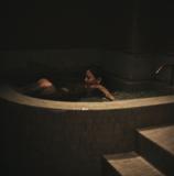 プライベートサウナルームの水深深い超軟水の水風呂につかる女性