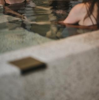 プライベートサウナルームの水深深い超軟水の水風呂で楽しむ3名の女性